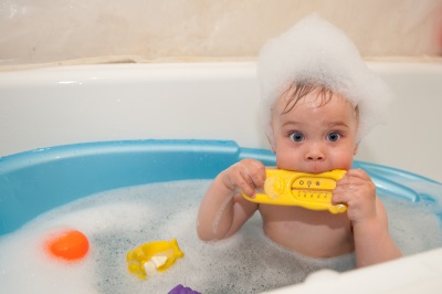Der Junge badet in einem Bad mit einem Thermometer für Wasser