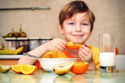 Rapaz comendo laranja