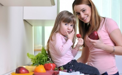 Mãe e filha comem frutas